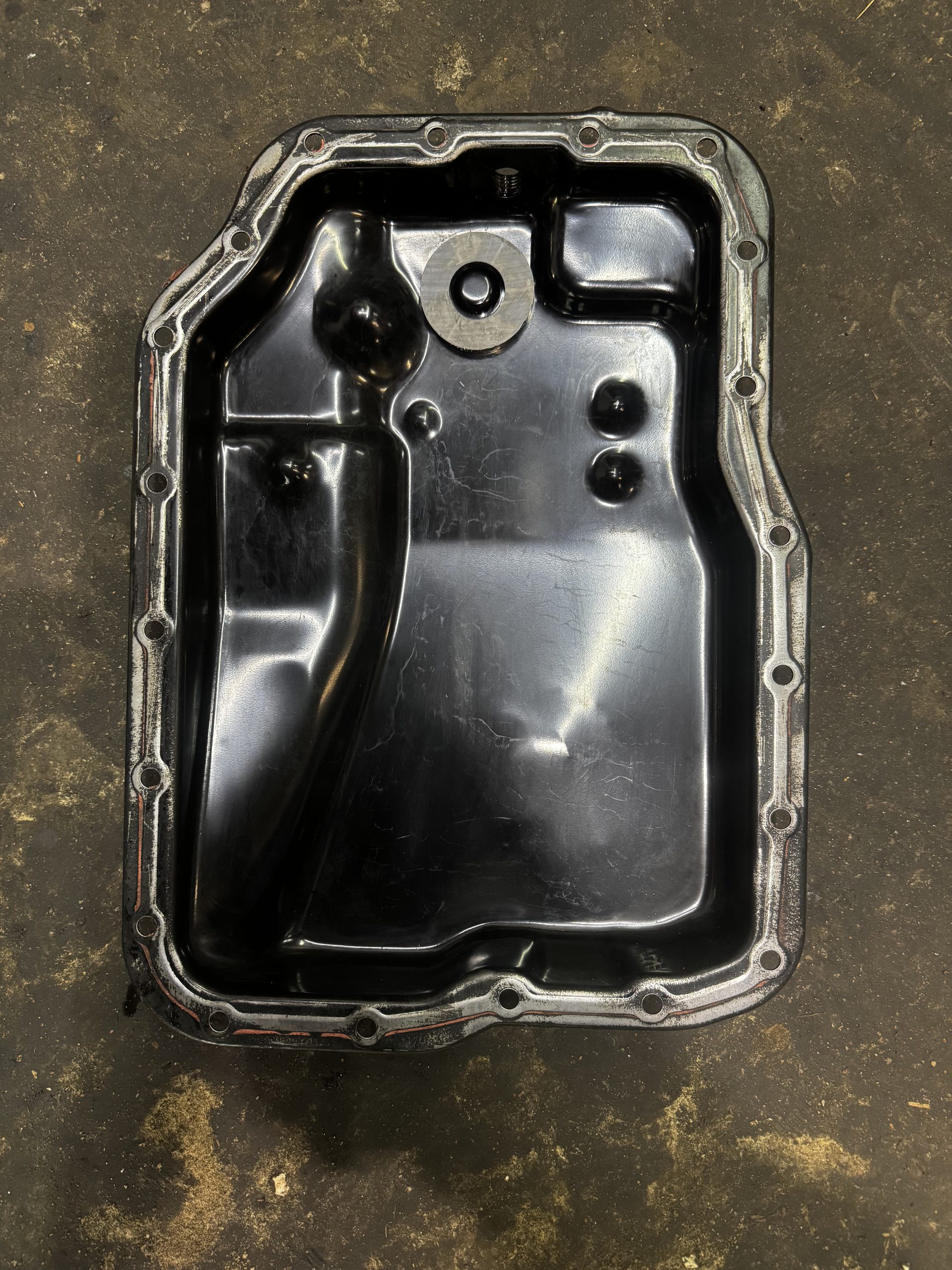 The same Mazda 5 transmission pan after cleaning at BR Prestige Auto Atlanta — magnet wiped to bare metal and gasket surface prepped for reinstallation