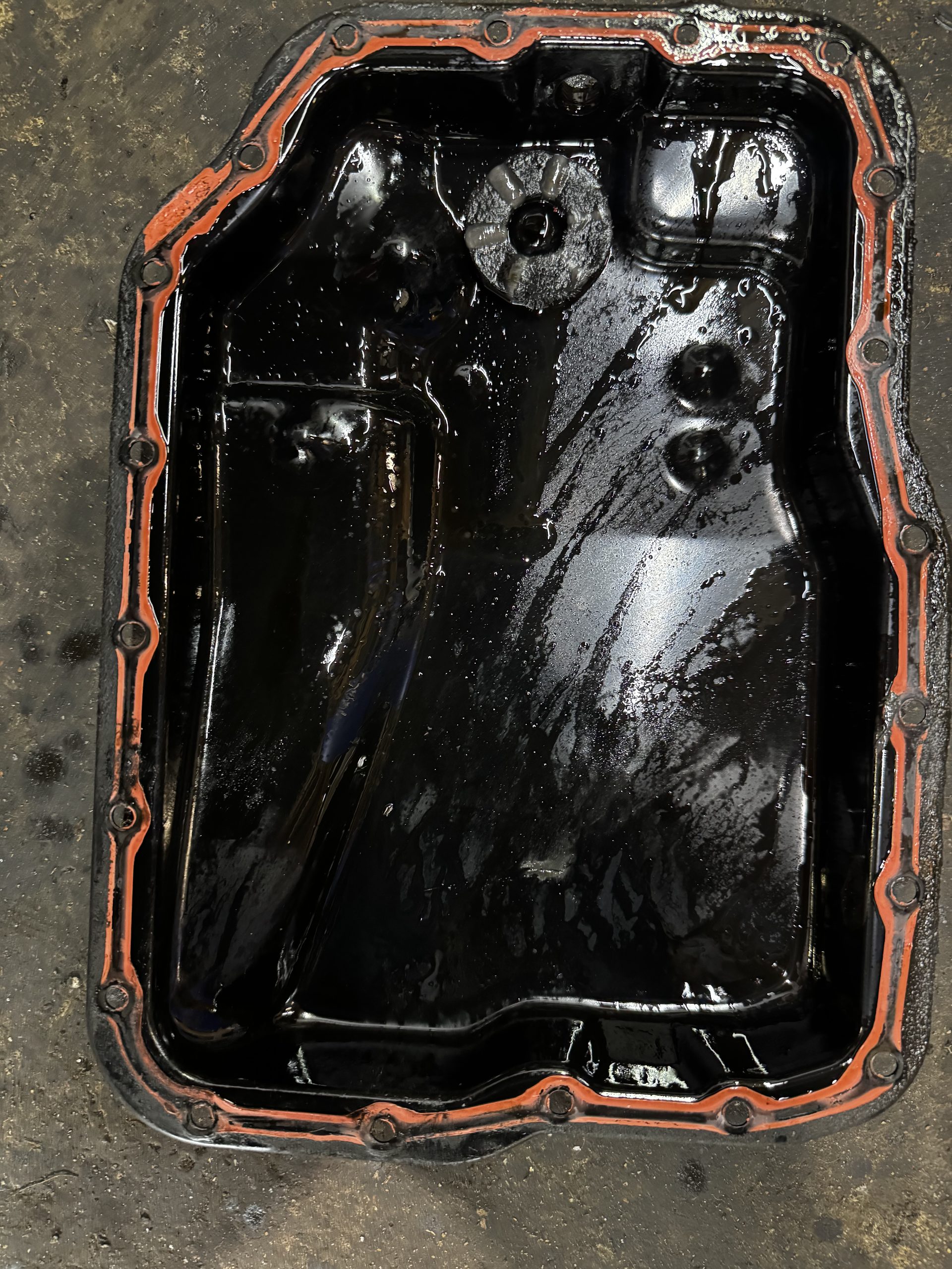 2007 Mazda 5 automatic transmission oil pan with accumulated fluid and debris before cleaning at BR Prestige Auto in Peachtree Corners, GA